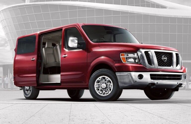 Front passenger angle of a red 2020 Nissan NV Passenger with its rear door open