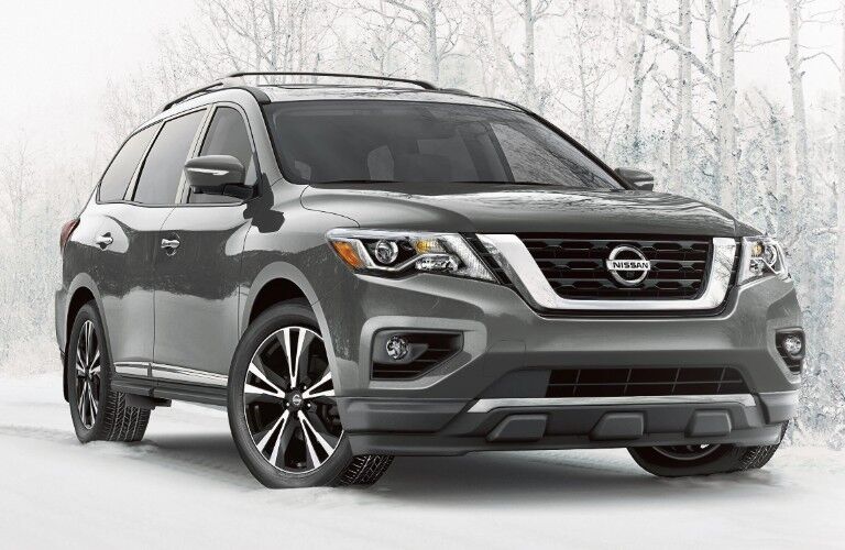Front passenger angle of a grey 2020 Nissan Pathfinder parked in the snow