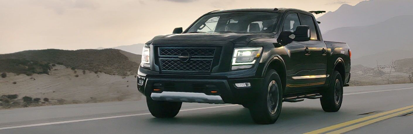 Front driver angle of a black 2020 Nissan TITAN driving on a road