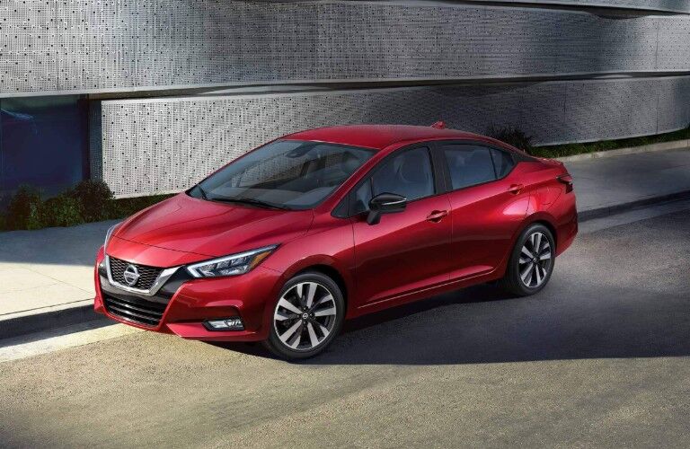 Front driver angle of a red 2020 Nissan Versa parked on the side of a street
