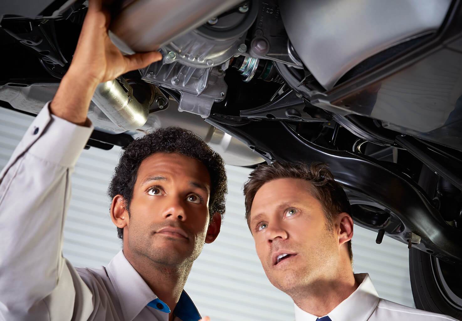 Two men going through a vehicle service inspection