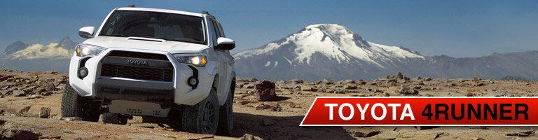 White Toyota 4Runner parked on mountain top with peaks in background