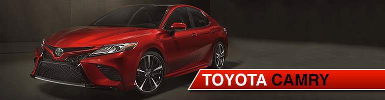 Red 2018 Toyota Camry parked on night street with text to the right of image