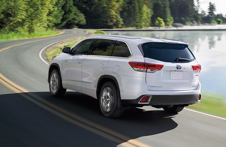 White 2019 Toyota Highlander driving by a lake