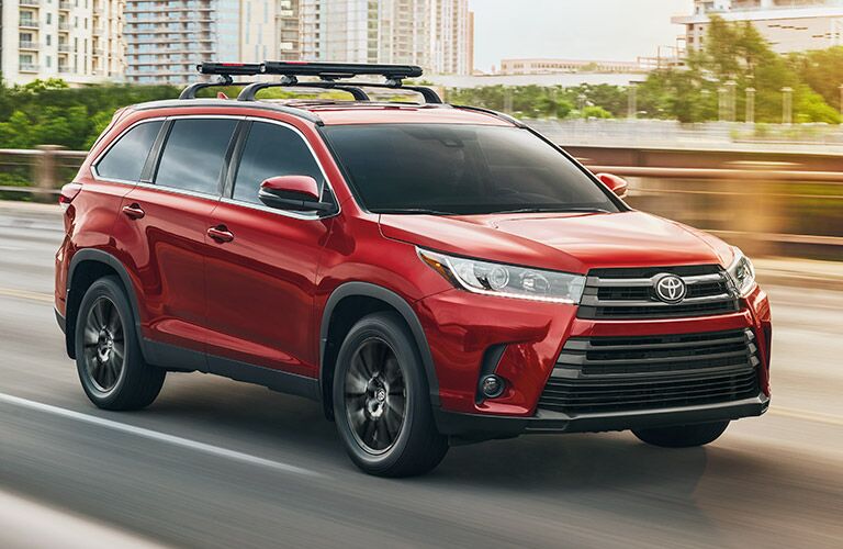 Red 2019 Toyota Highlander driving on a highway