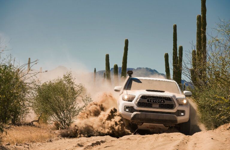 white 2018 Toyota Tacoma TRD Pro driving through sand