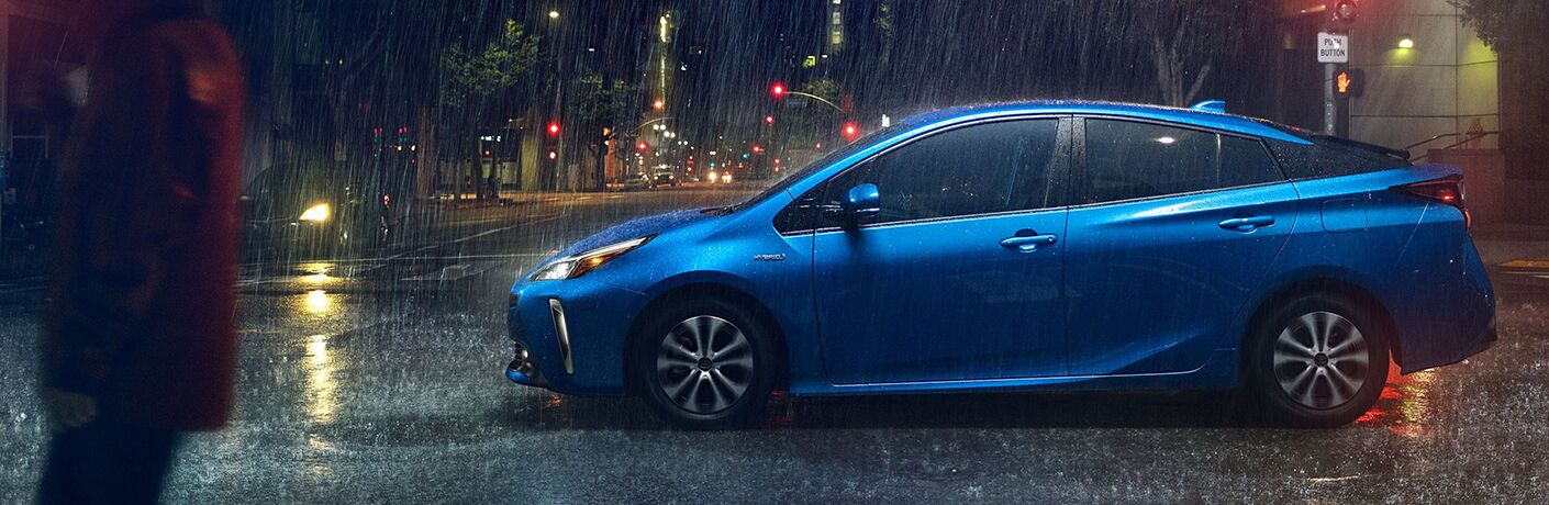 Blue 2020 Toyota Prius driving on a rainy street