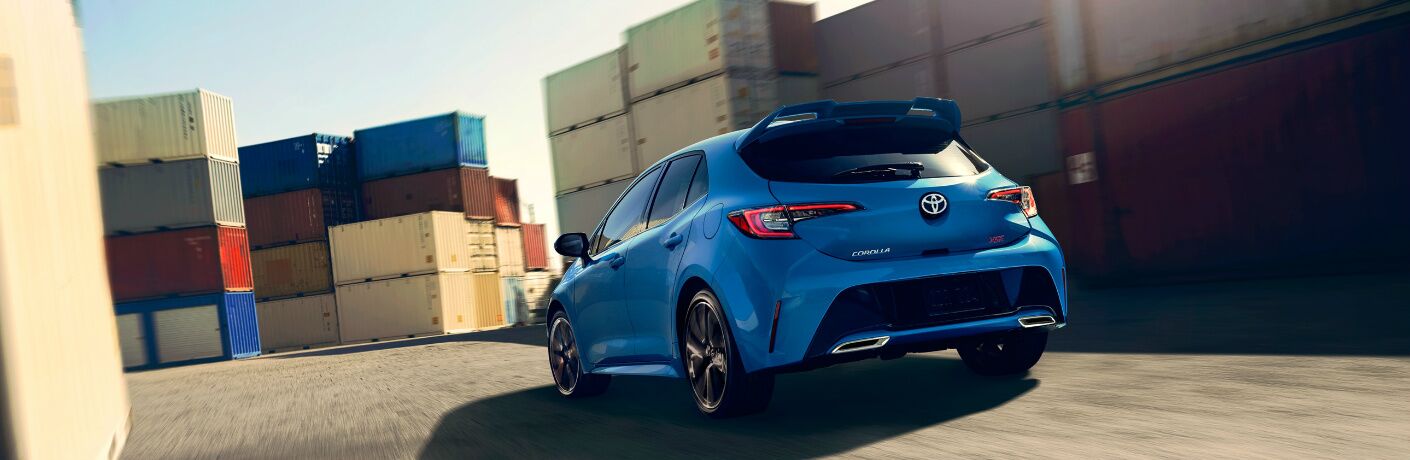 Blue 2020 Toyota Corolla Hatchback driving by some shipping containers