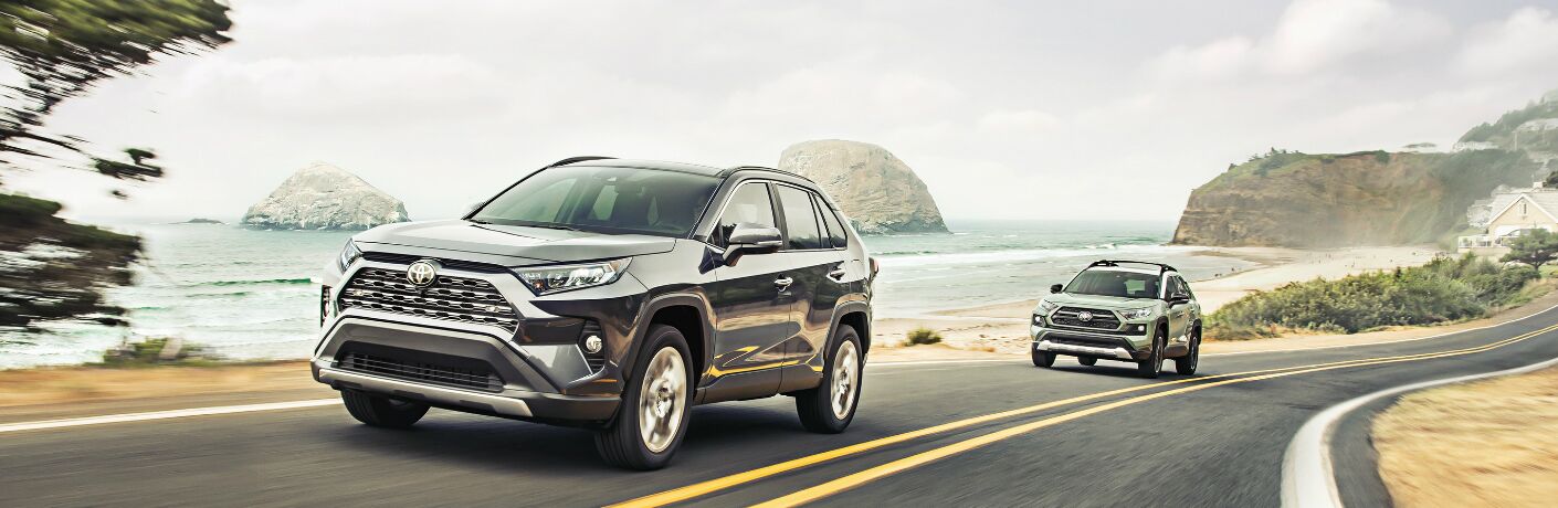 Two 2020 Toyota RAV4 vehicles driving on a coastal road