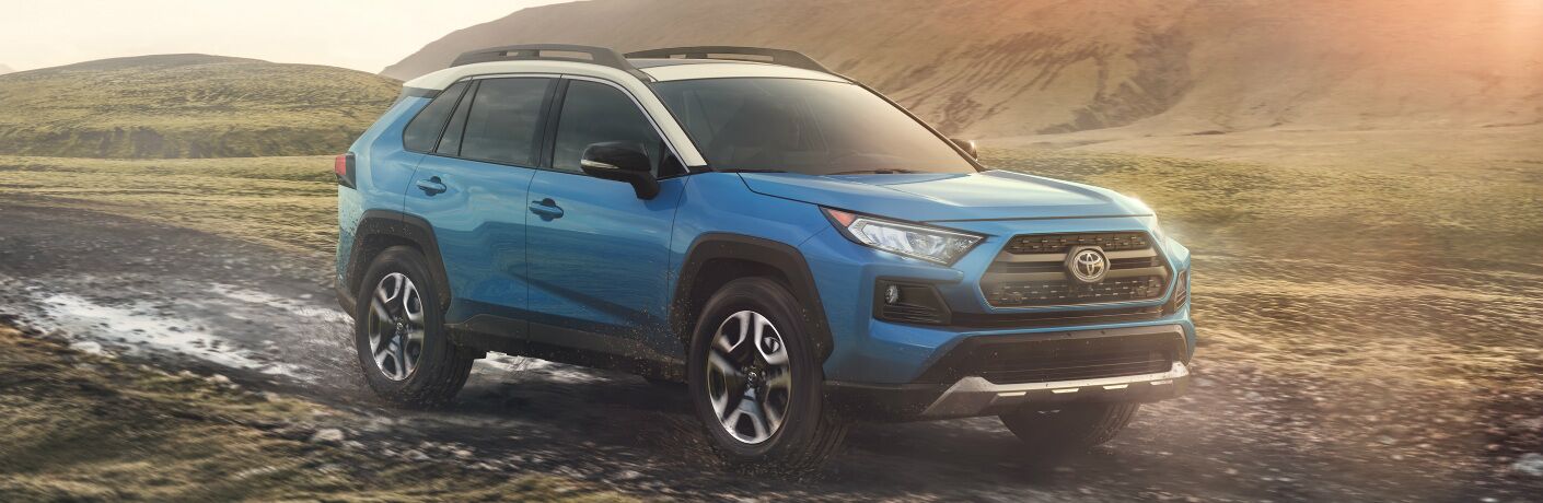 Blue 2020 Toyota RAV4 Hybrid driving on a muddy road