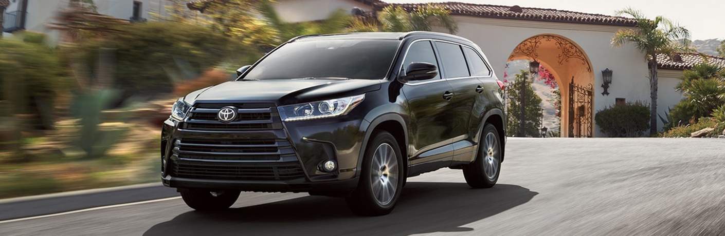 black 2018 Toyota Highlander driving in a community