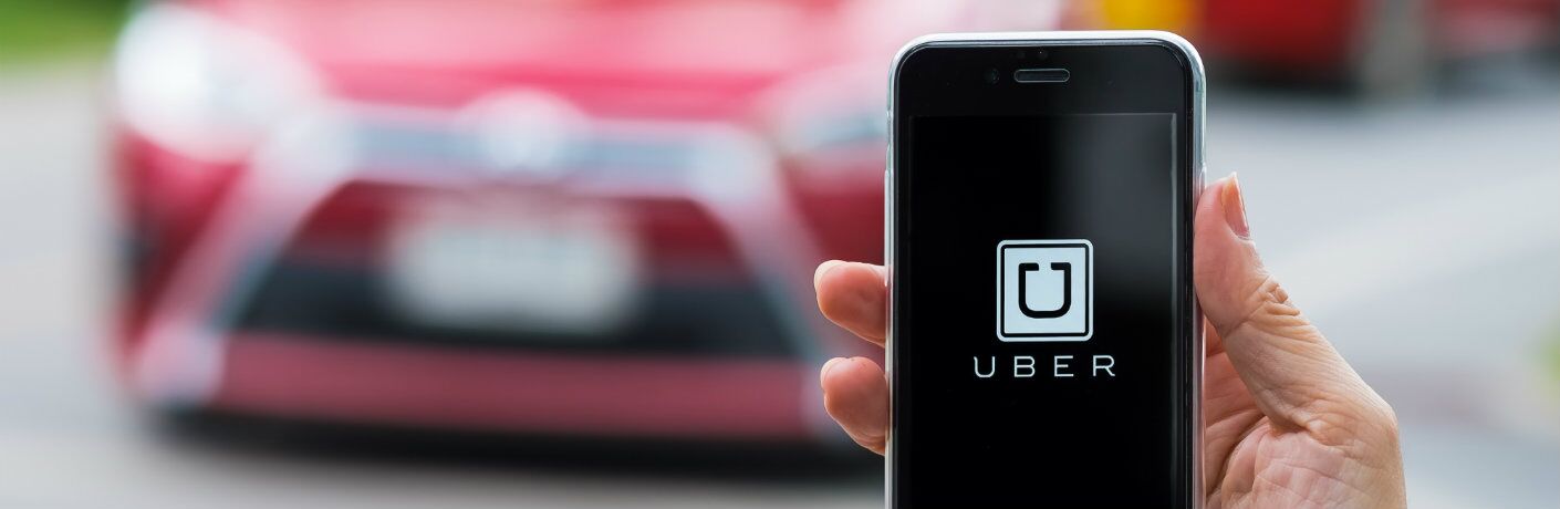 Uber_app_on_phone_with_red_car_in_background