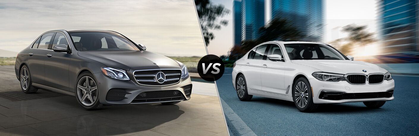 2019 MB E 300 sedan exterior front fascia and passenger side vs 2019 BMW 530i sedan exterior front fascia and passenger side on blurred city background
