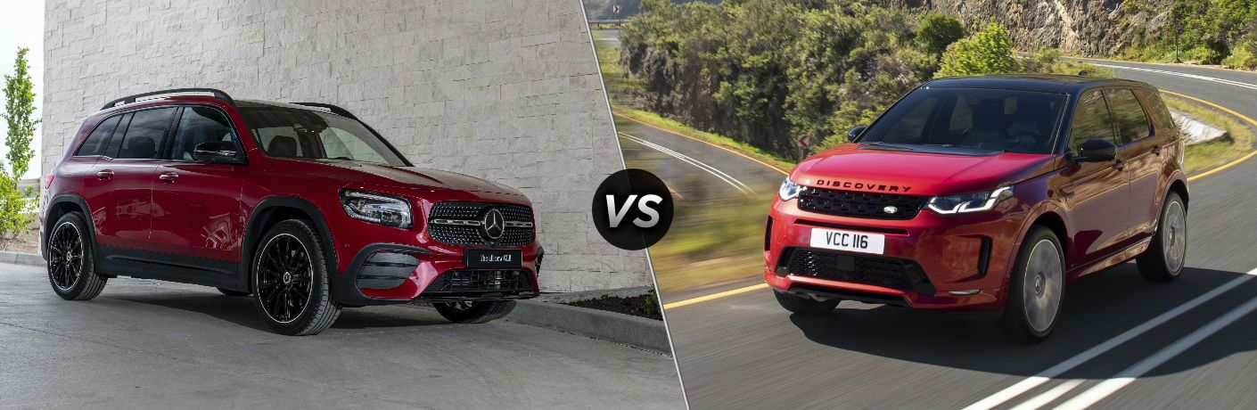 2020 MB GLB exterior front fascia and passenger side in front of brick wall vs 2019 Land Rover Discovery Sport exterior front fascia and drivers side on winding highway