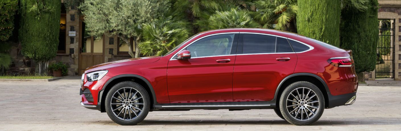 2020 MB GLC Coupe exterior driver side profile parked in front of building with foliage