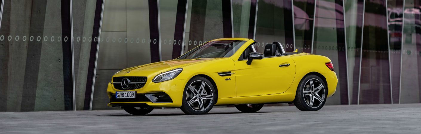 2020 MB SLC Final Edition exterior front fascia and drivers side parked next to building with dark reflective glass