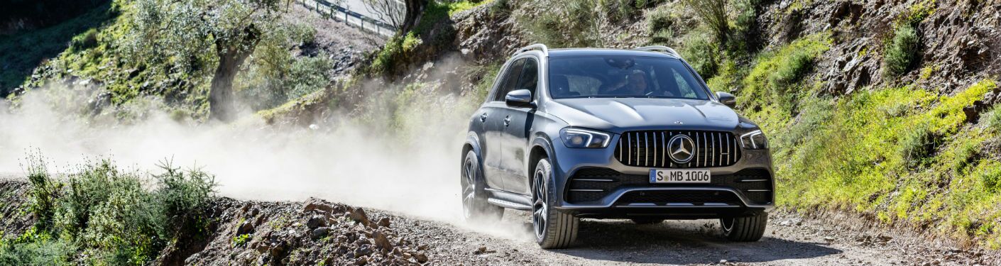 2021 MB AMG GLE 53 exterior front fascia and passenger side going fast on dirt road on hill