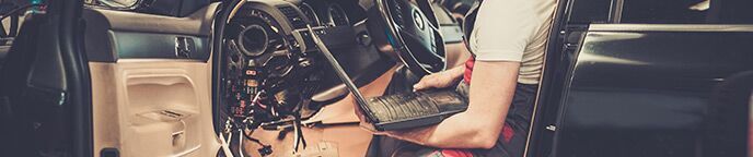 service technician in vehicle with laptop