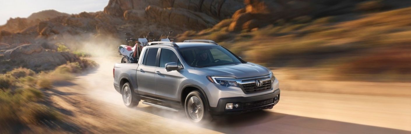 A 2017 Honda Ridgeline with two dirtbikes in its bed