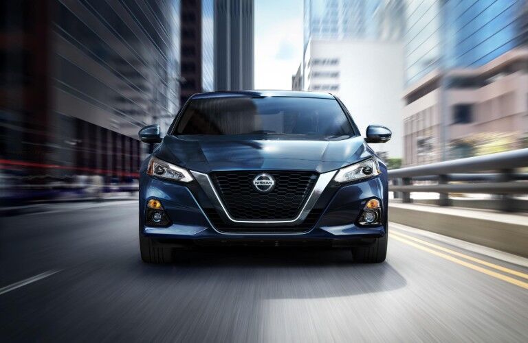 Front angle of a blue 2020 Nissan Altima driving on a road