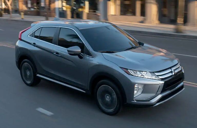 2020 Mitsubishi Eclipse Cross gray driving right in shadow of building in city