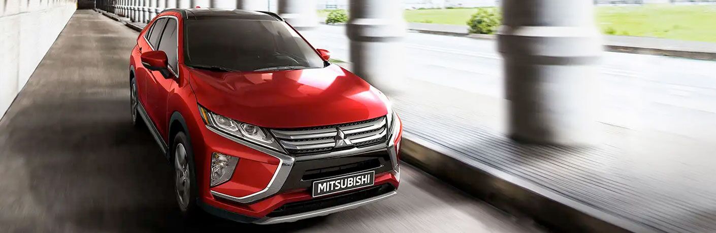 2020 Mitsubishi Eclipse Cross red driving past pillars with motion blur