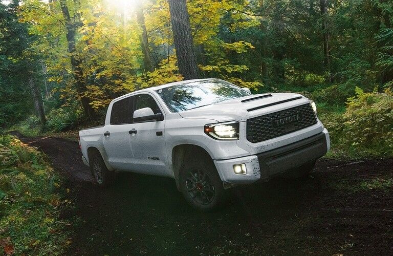 White 2021 Toyota Tundra driving through a forest