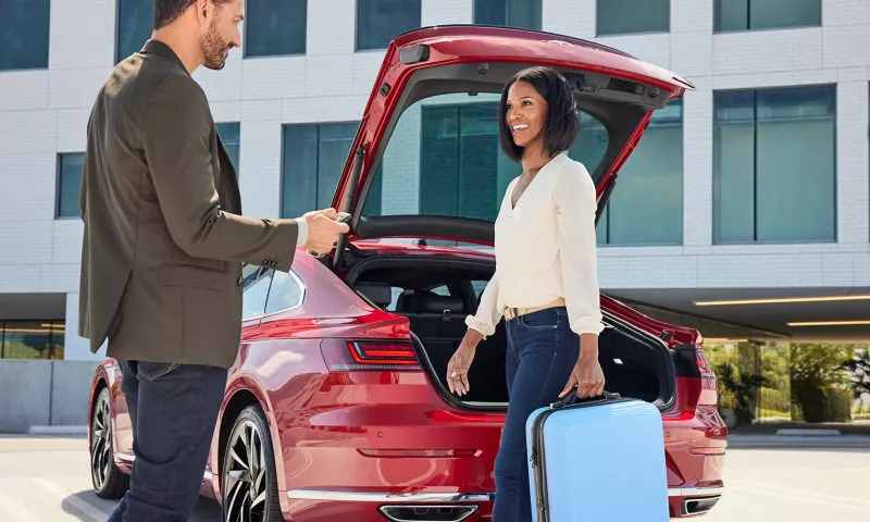 A couple putting luggage in the hatchback of the 2023 VW Arteon.