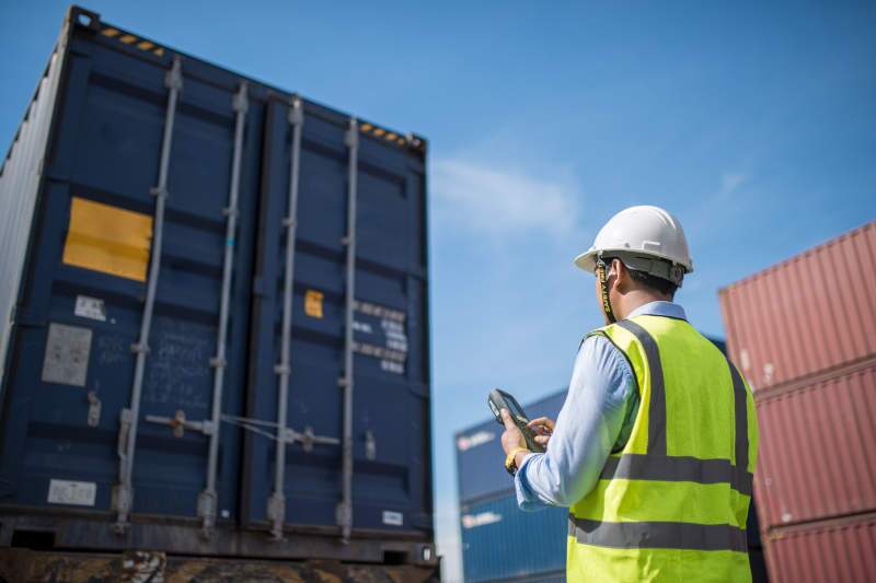 A man doing a pre-trip inspection on a heavy commercial truck.