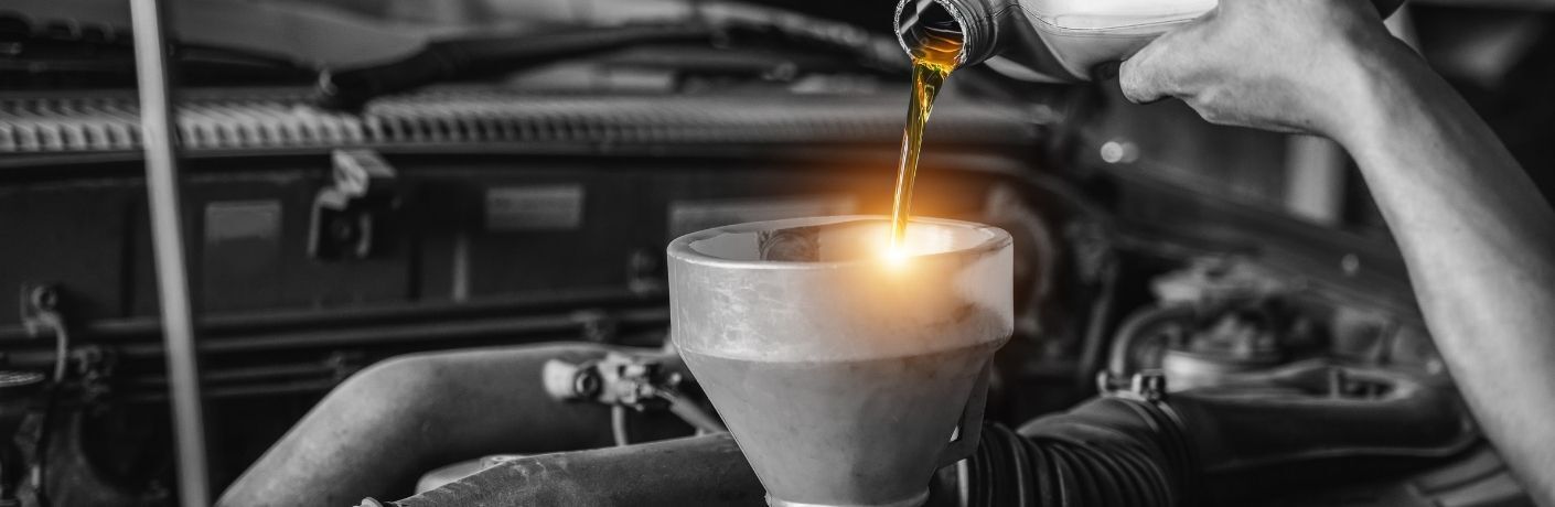 Man pouring new engine oil to a car