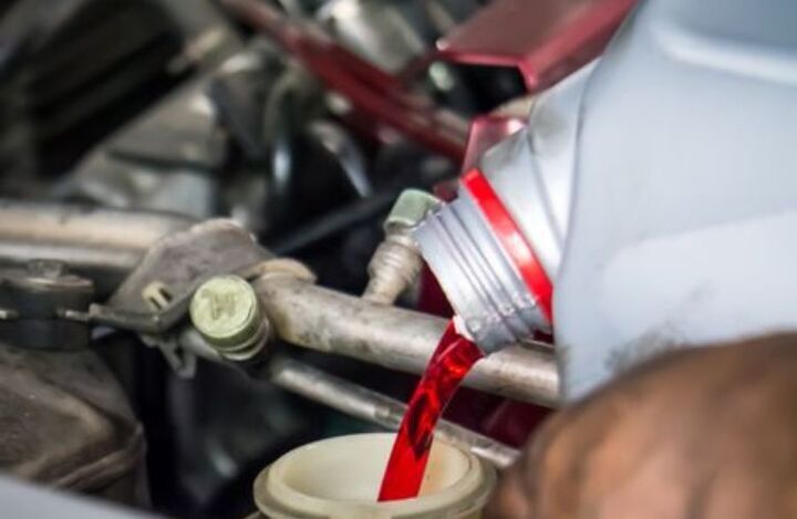 Mechanic pouring fresh transmission in a car