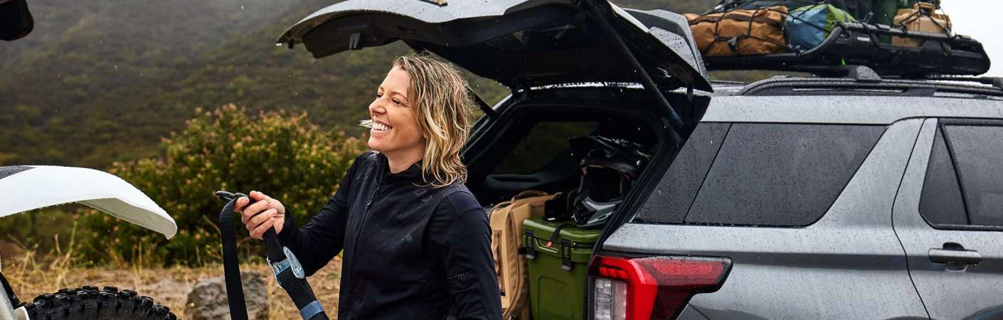 The exterior of the 2026 Ford Explorer with the cargo door open and gear loaded on the roof