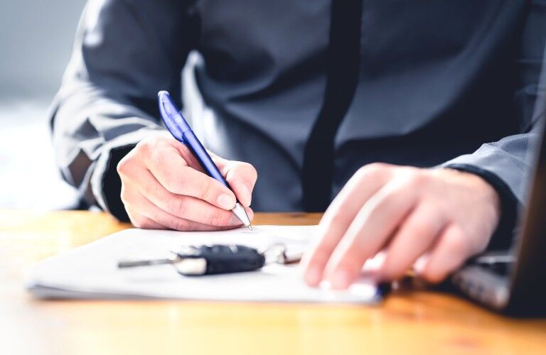 Person signing a car application form