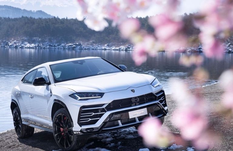 front view of the Lamborghini Urus with a lake in background