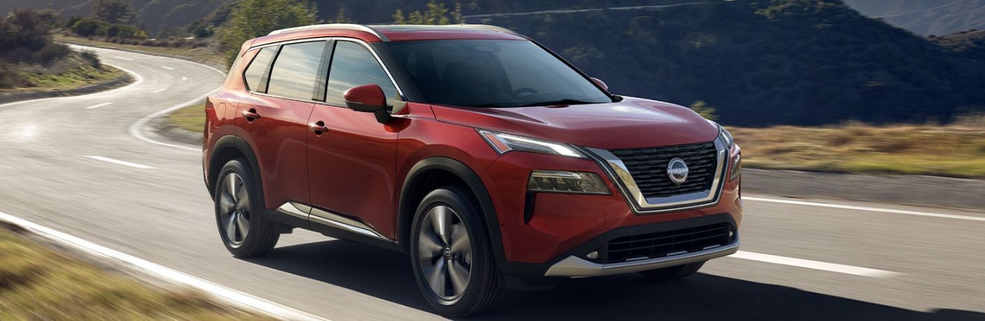 2023 Nissan Rogue® Red driving on the road