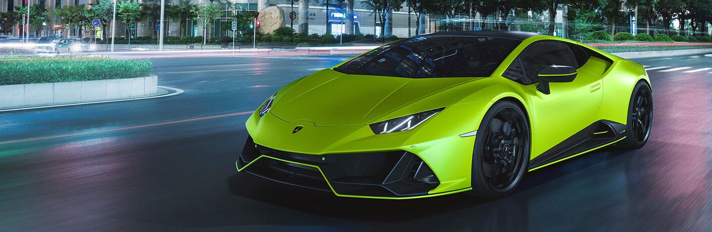 2021 Lamborghini Huracan lime green exterior front fascia driver side driving on city street