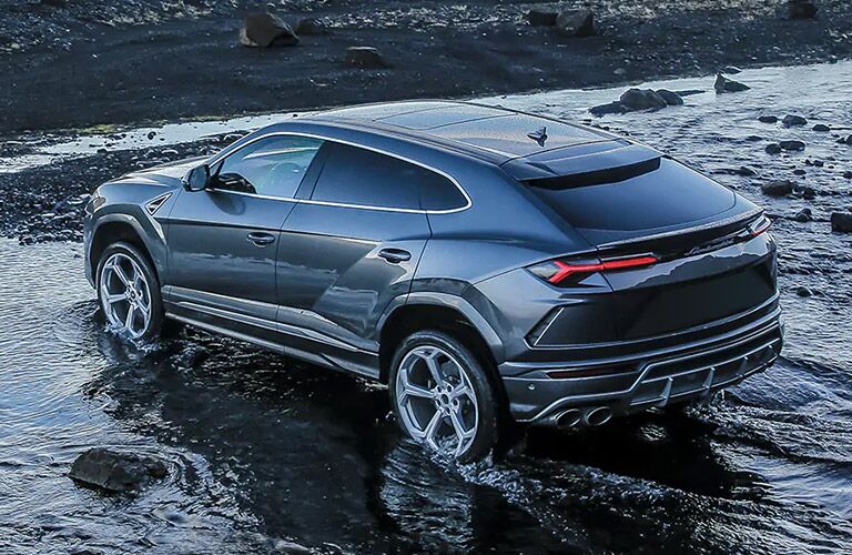 2021 Lamborghini Urus grey exterior rear fascia driver side driving on a beach