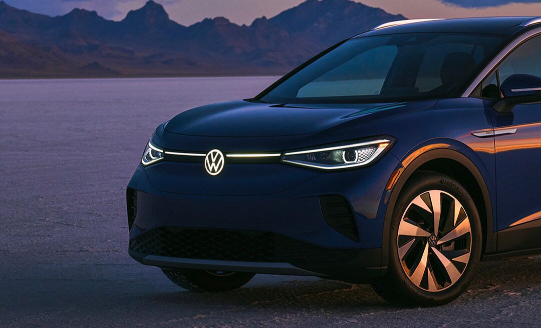 A ¾ front of an ID.4 in Dusk Blue Metallic in a natural sunset setting.