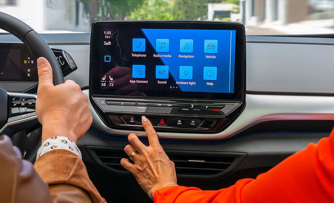 A close-up shot of a woman’s hand touching the ID.4 available 12" touchscreen display.