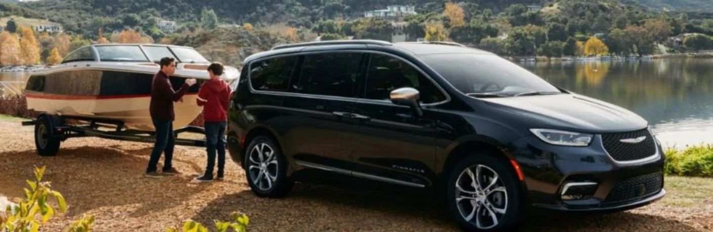 Two gentleman standing with their 2023 Chrysler Pacifica parked