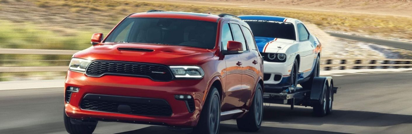 Red Dodge Durango towing a car