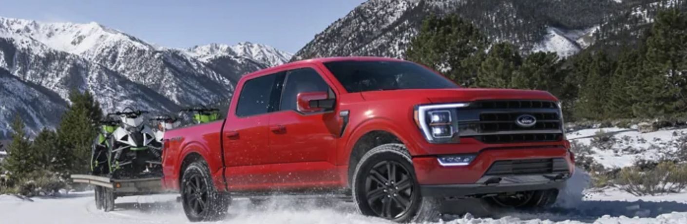front quarter view of the 2023 Ford F-150 towing motorcycles in snow
