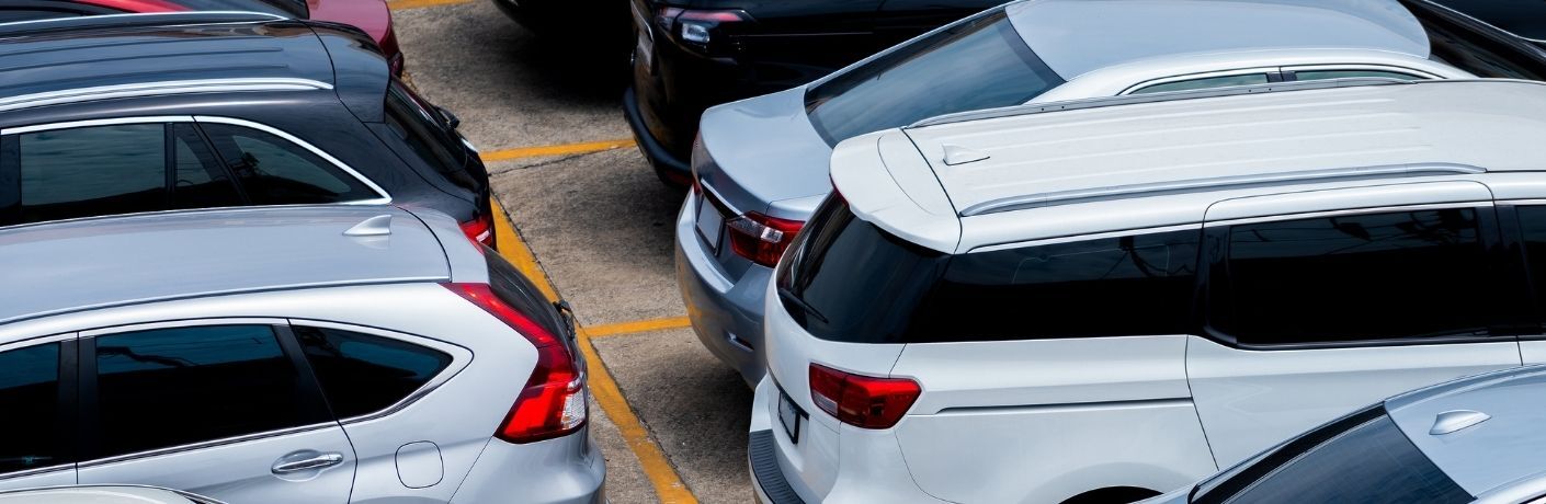 rear view of several used cars parked at a parking lot