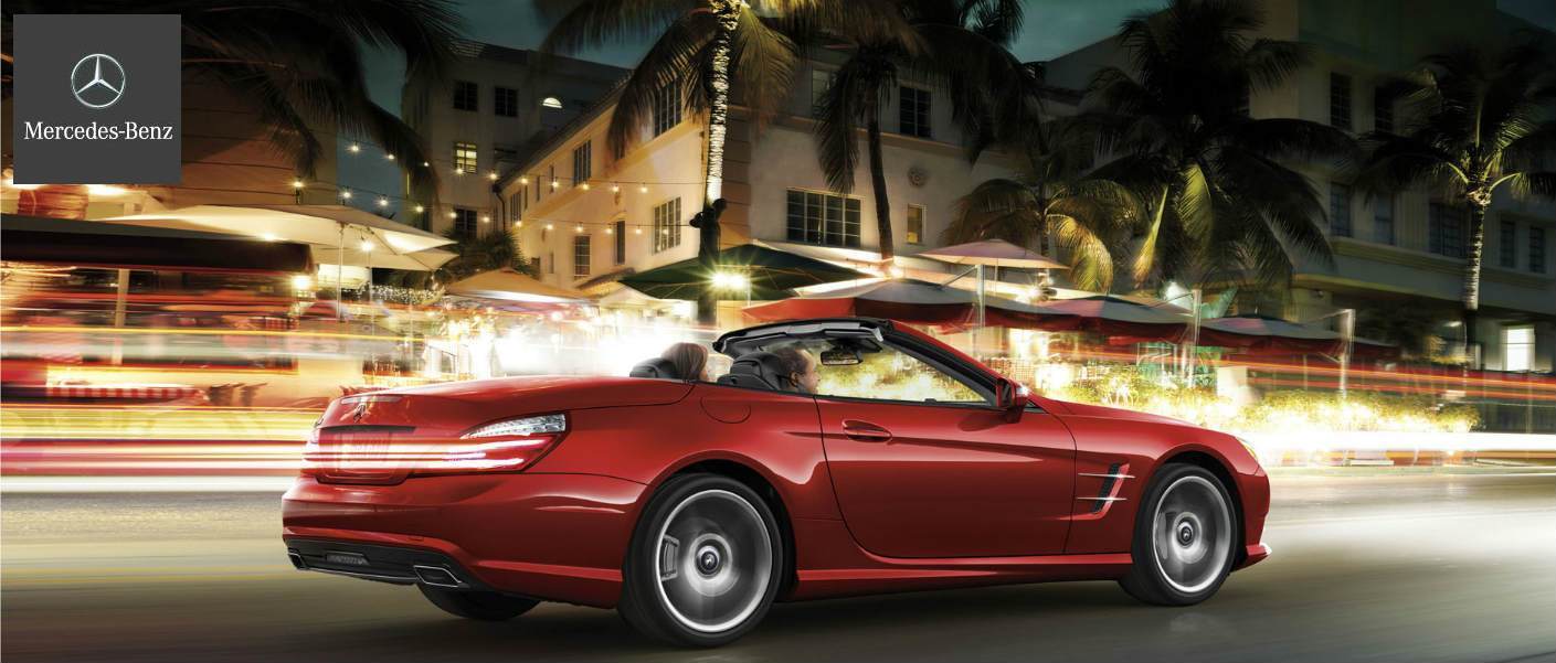 2015 Mercedes-Benz SL-Class driving down brightly lit tropical street at night