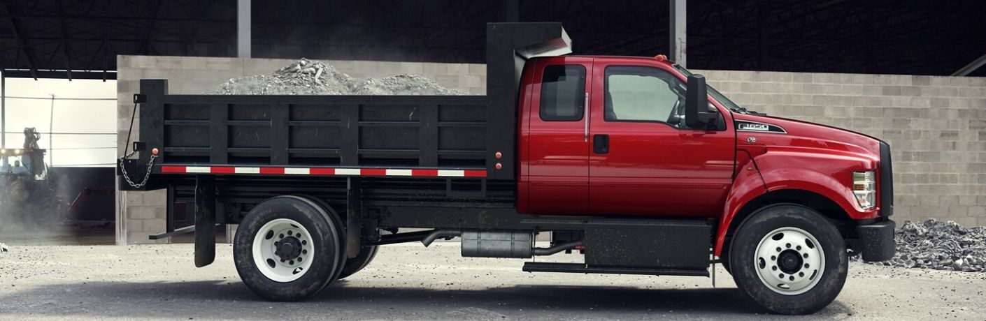 Side view of the 2024 Ford F-650 Red Commercial Truck at construction site