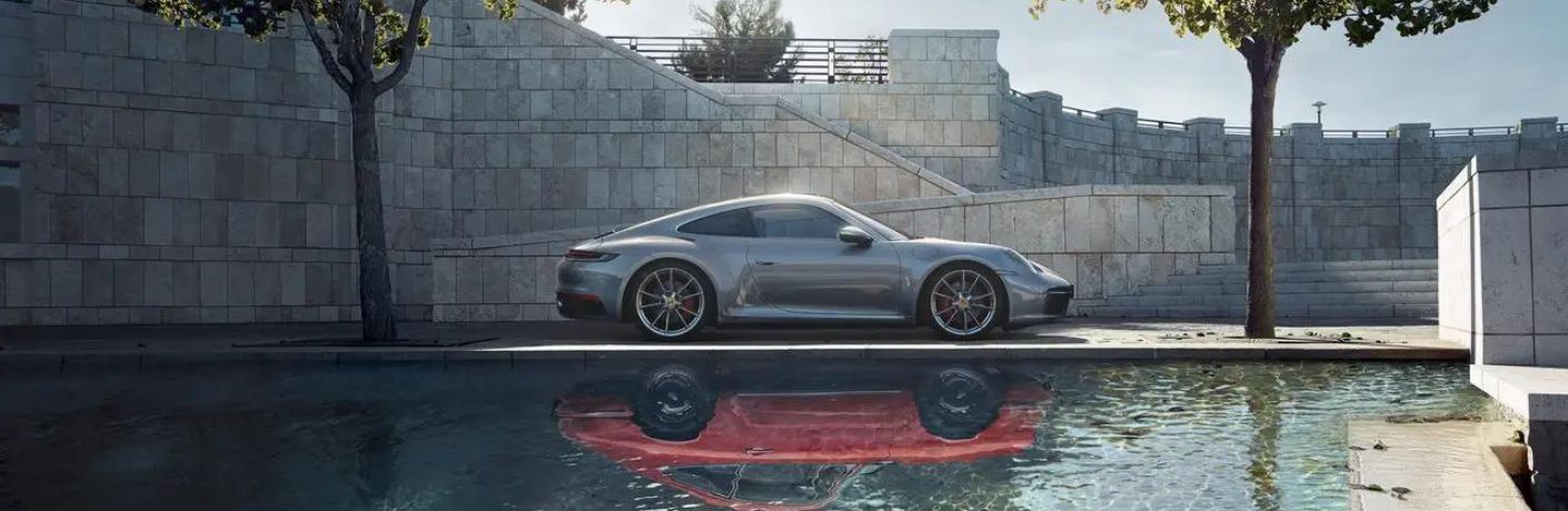 One grey color 2022 Porsche 911 is parked near a water body.