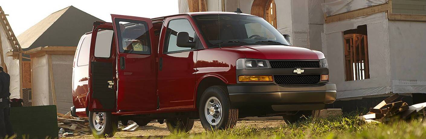 Red 2018 Chevy Express parked by a house under construction