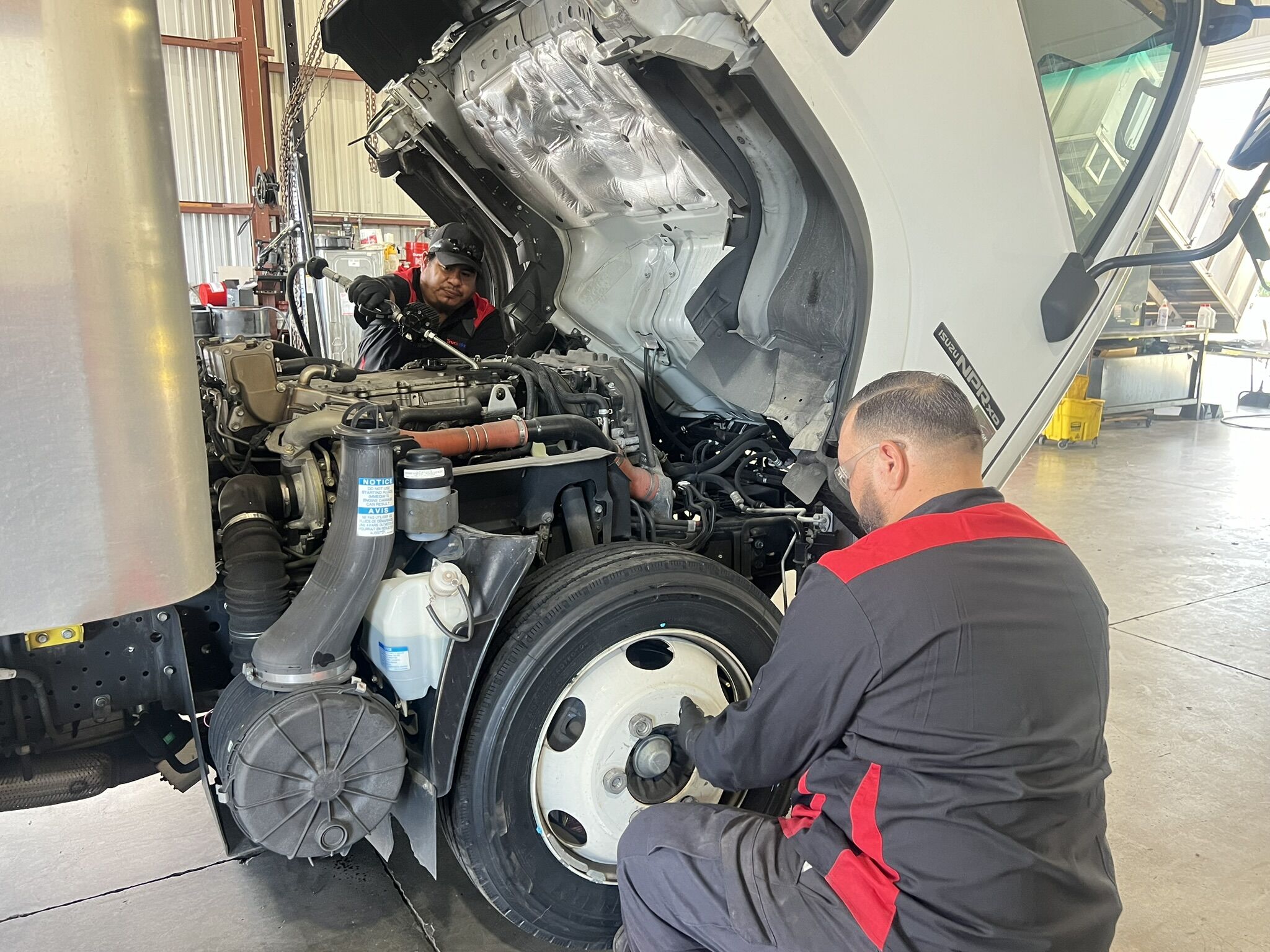 A man performing service on a commercial truck engine