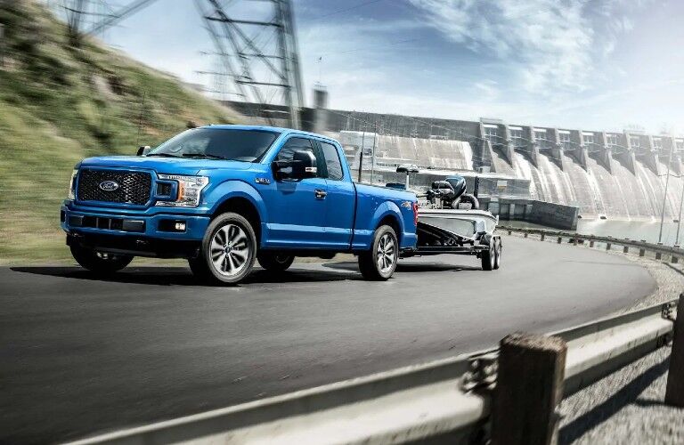 Front view of 2020 Ford F-150 Platinum towing trailer on winding road
