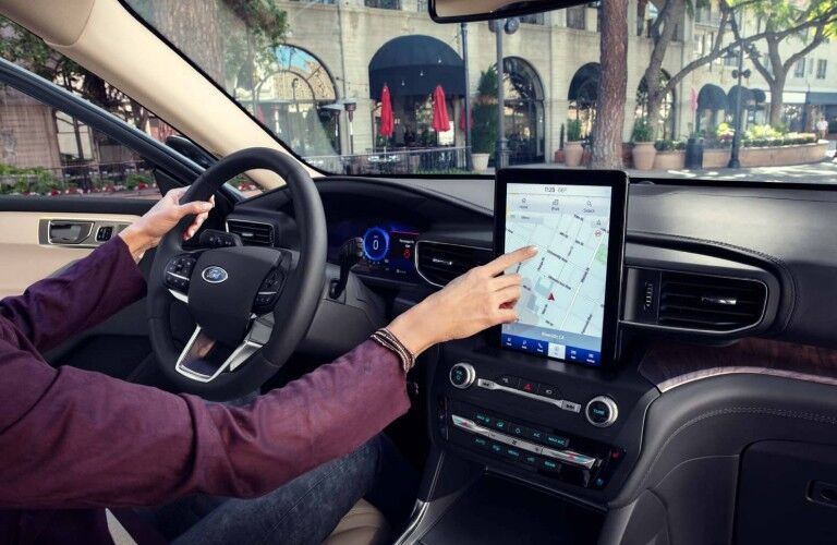 Hand operating 2020 Ford Explorer Platinum centre touchscreen